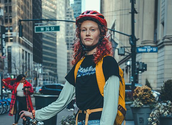 Eine junge Frau mit Rad in einer Großstadt