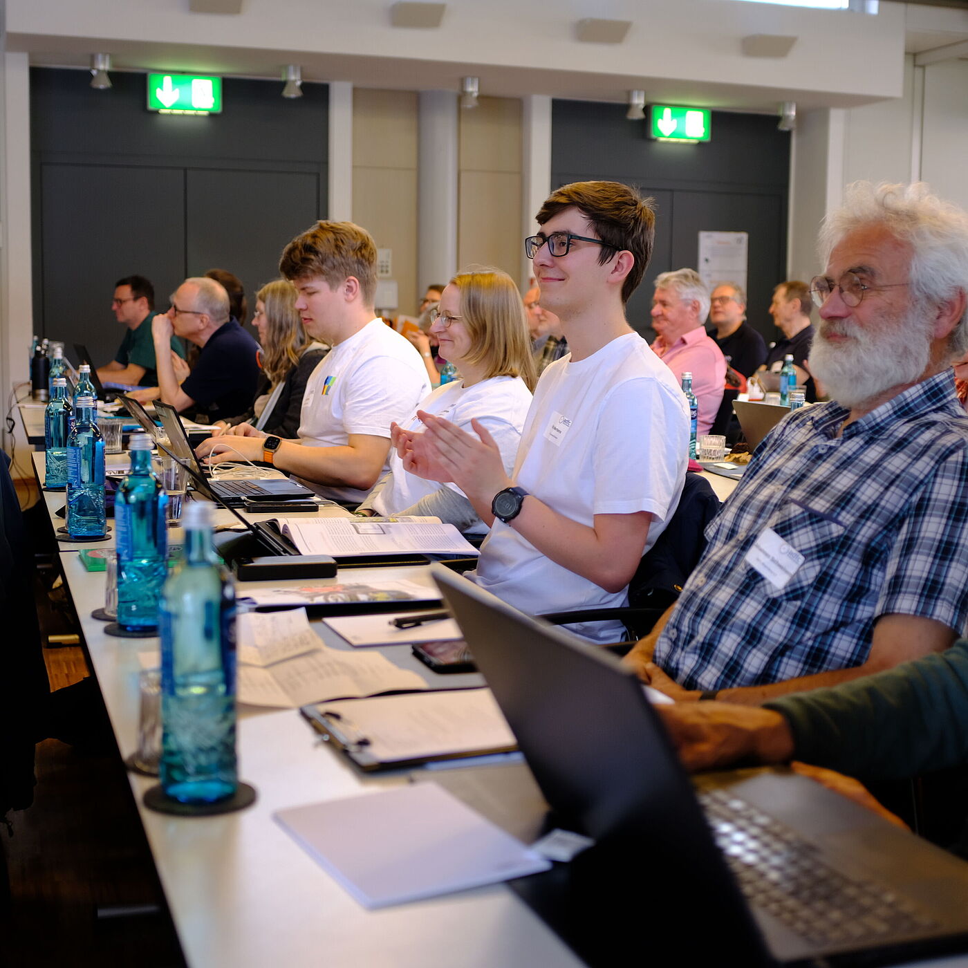 Mehrere Personen sitzen vor einem PC. 
