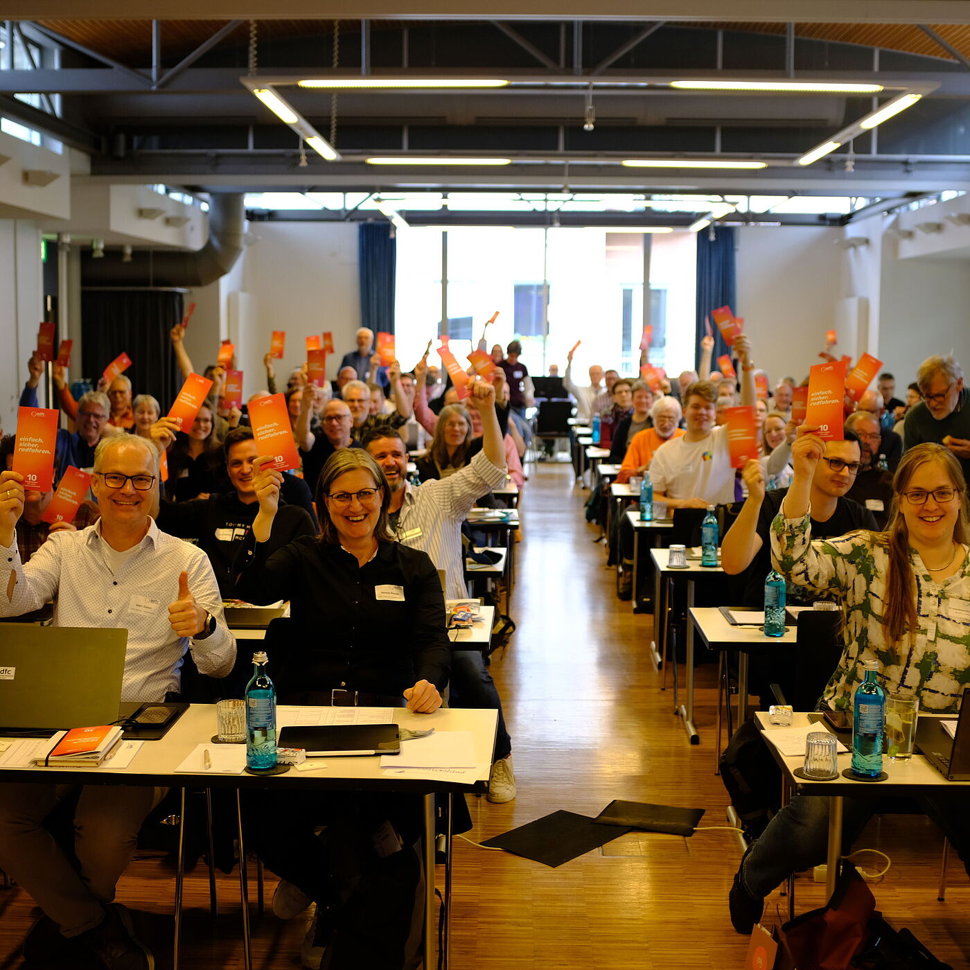 Viele Delegierten halten einen Flyer hoch